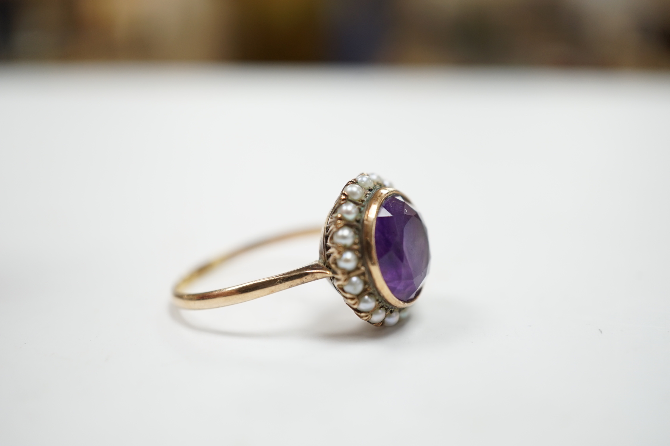 A mid 20th century 14k yellow metal, amethyst and seed pearl set circular cluster ring, size U/V, gross weight 4.3 grams.